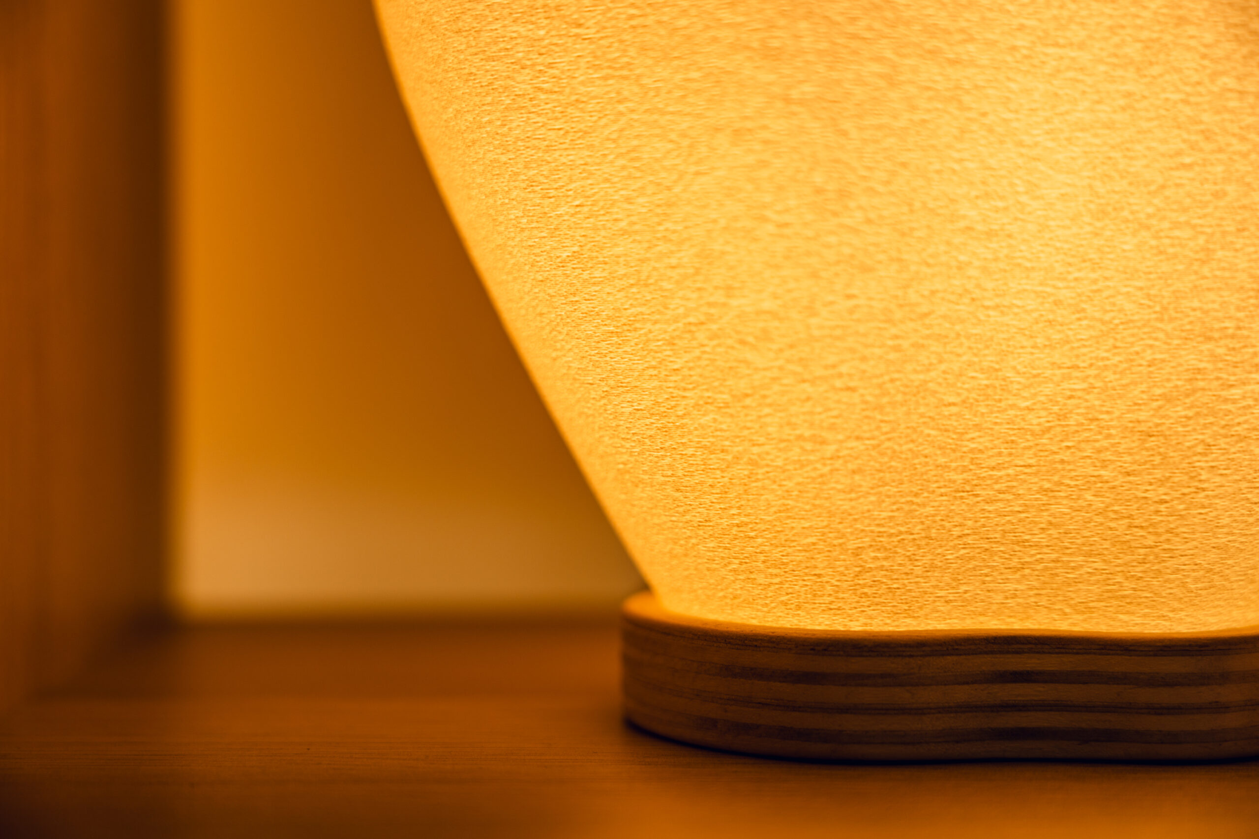 Detalle cálido de lámpara Luz de Asturias sobre base de madera